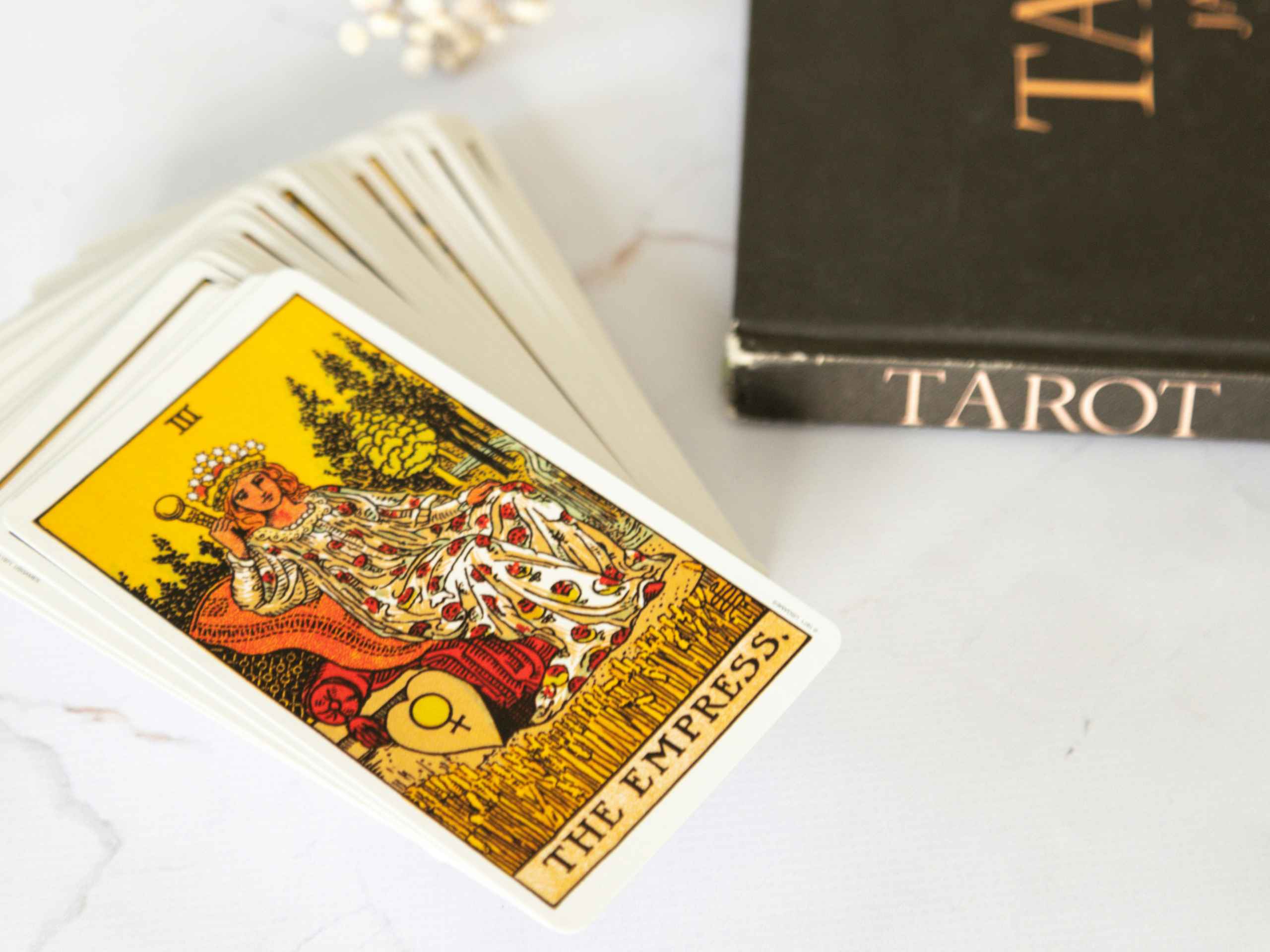 Tarotkaarten: stapeltje tarotkaarten en een boek over tarot